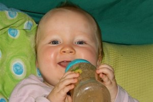 Bébé souriant avec un biberon